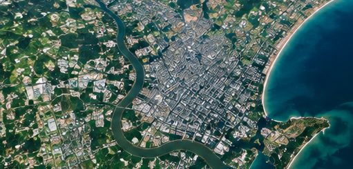 Satellite view of an urban river delta and coastline